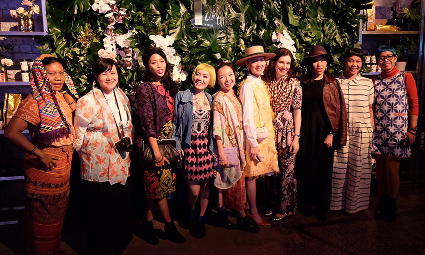A group of women in colourful dresses laugh and enjoy their time in Australia